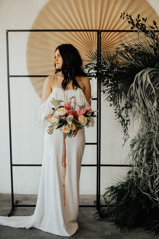 Elegant bride holds bouquet in modern wedding setting