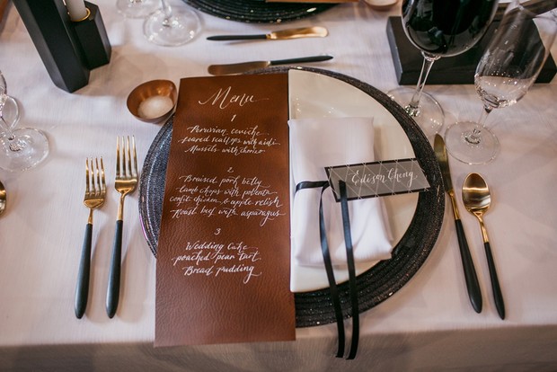 leather menu and black and white place setting