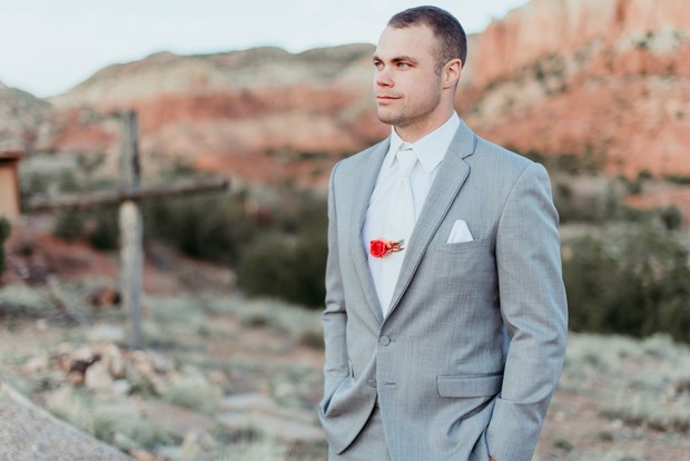 groom style with floral tie clip