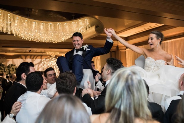 Bride and groom lifted at wedding reception hora dance