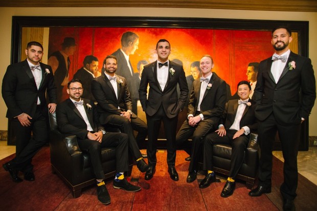 Groom and groomsmen in black tuxedos for a wedding