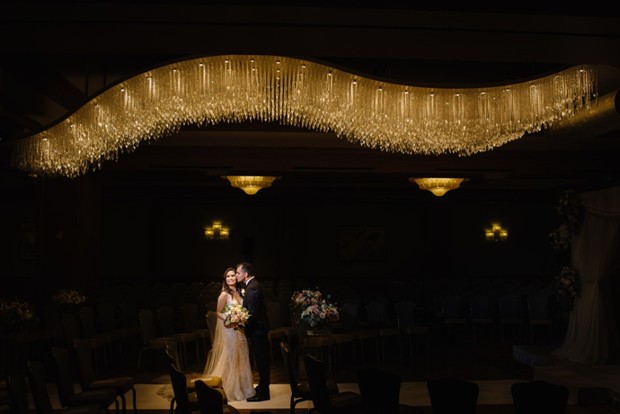 Bride and groom under a stunning crystal chandelier