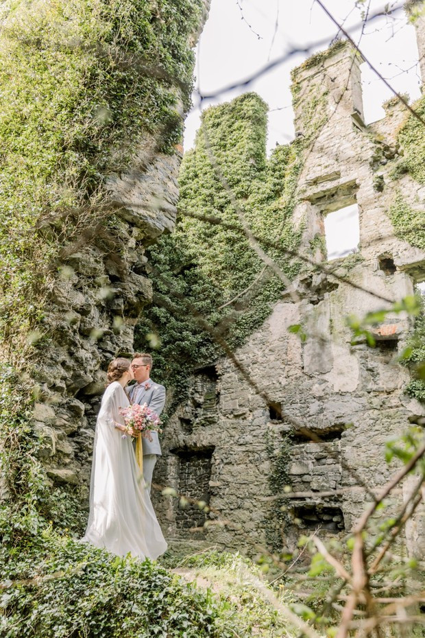 Newlyweds at ivy covered castle ruins wedding photo