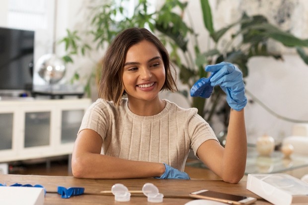 Woman smiling while preparing dental impressions at home