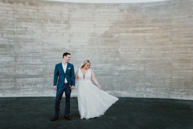 Newlyweds holding hands at their modern wedding shoot