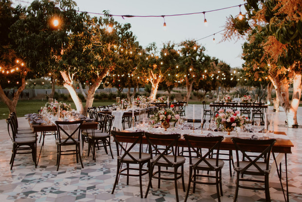 Outdoor wedding reception setup with tables and string lights