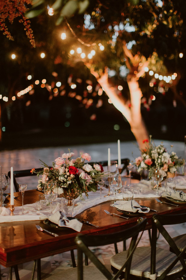 Romantic outdoor wedding table setting with string lights above