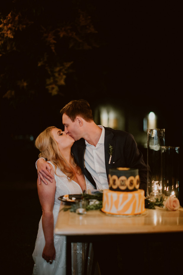 Newlyweds share a kiss in the night during their wedding celebration