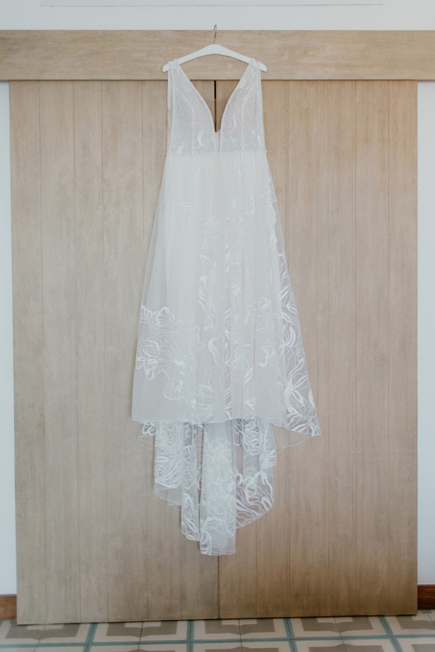Elegant white wedding dress hanging on a wooden door
