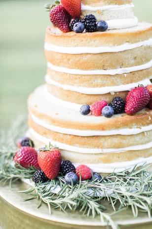 Naked wedding cake with fresh berries and rosemary
