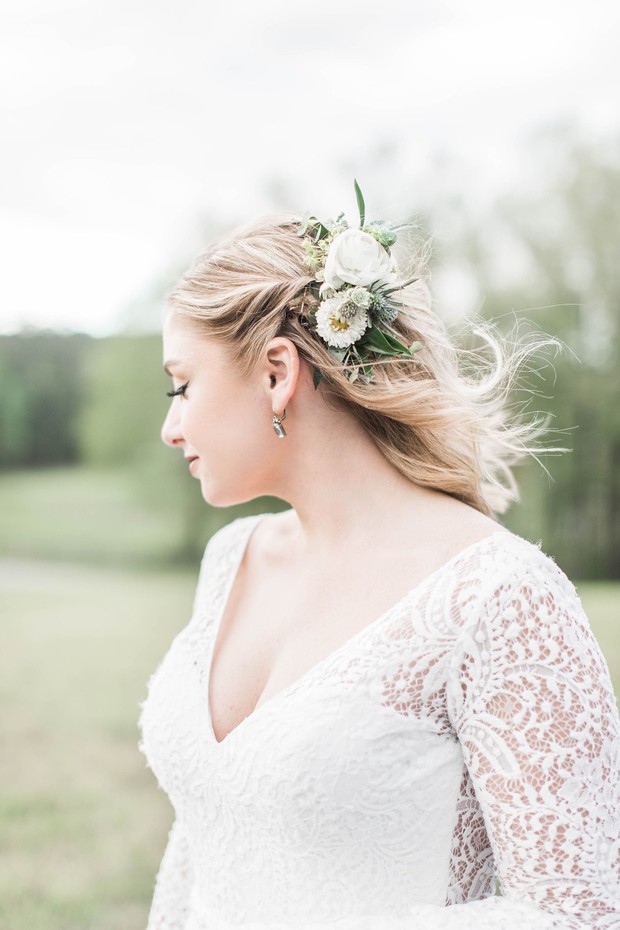 Bride with floral hairpiece in white lace wedding gown