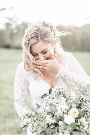 Bride laughing, holding a beautiful wedding bouquet