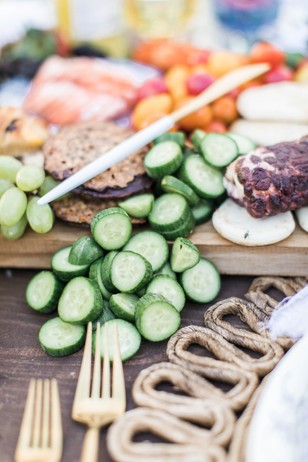 Gourmet charcuterie board with cucumbers and snacks