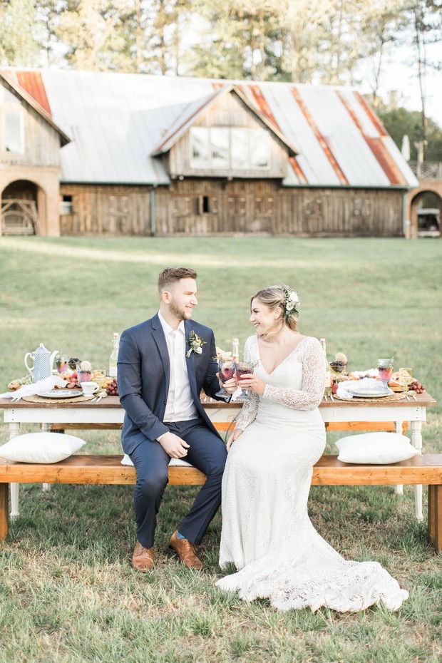 Bride and groom toasting at their rustic barn wedding