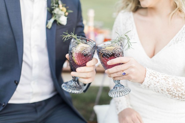 Newlyweds toasting with red drinks at their wedding