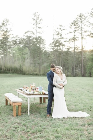 Happy couple embrace at their outdoor wedding table