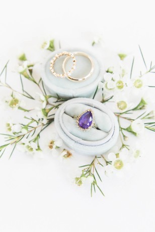 Wedding rings and amethyst ring in velvet ring boxes