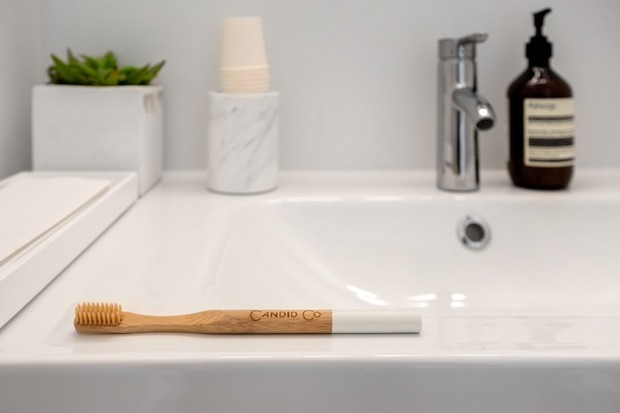 Wooden toothbrush on a modern bathroom sink counter