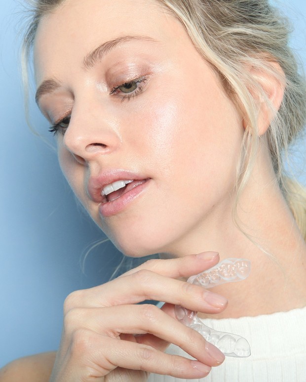 Woman holding clear aligners for teeth straightening