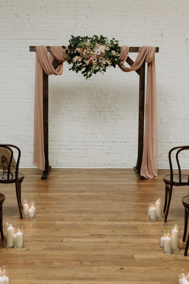 Elegant rustic wedding arch with flowers and candles
