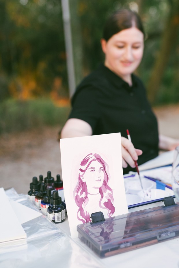 Artist paints a watercolor portrait at an outdoor event
