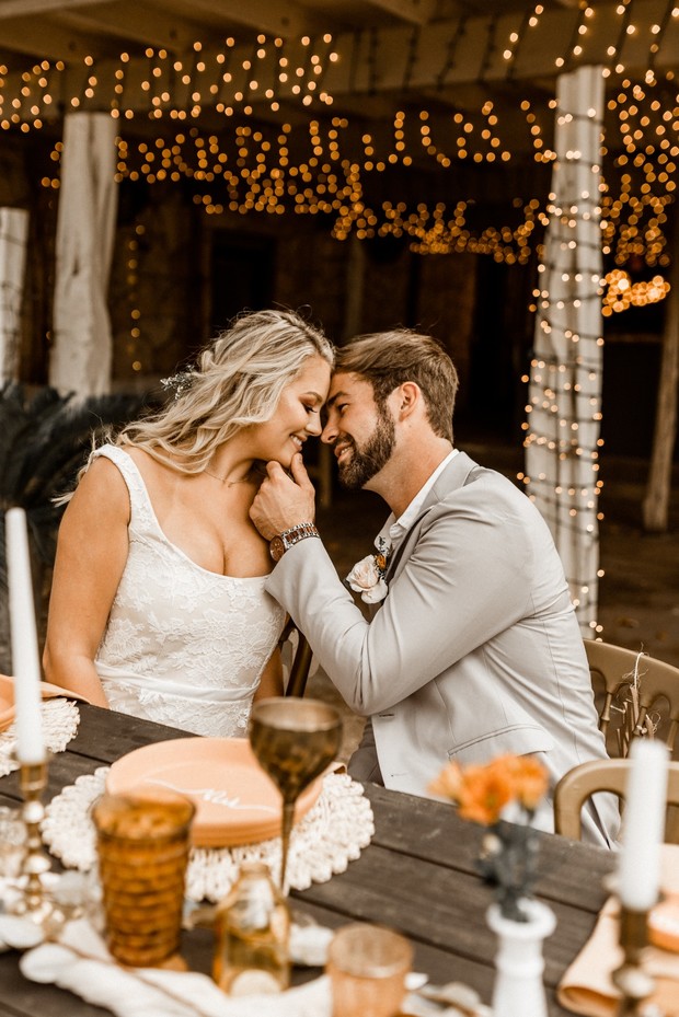 Romantic couple embraces at rustic wedding reception