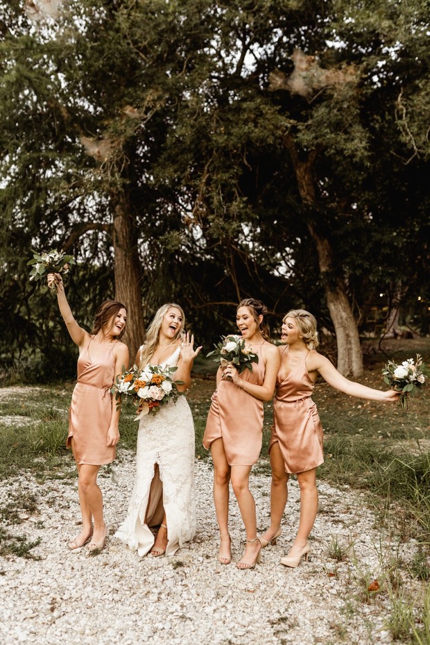 Bride and bridesmaids celebrate at outdoor wedding