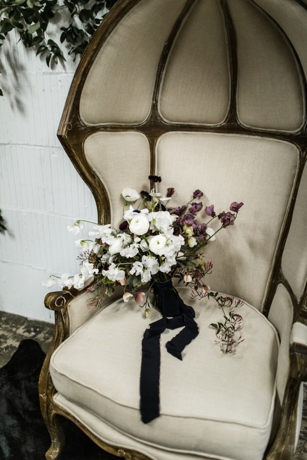 Wedding bouquet on antique chair with black ribbon
