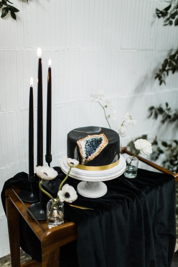 Elegant geode cake with candles and floral accents