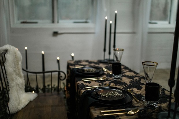 Elegant gothic table setting with black candles and gold cutlery