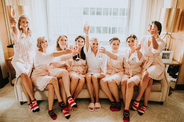 Bridesmaids in robes toasting with champagne glasses