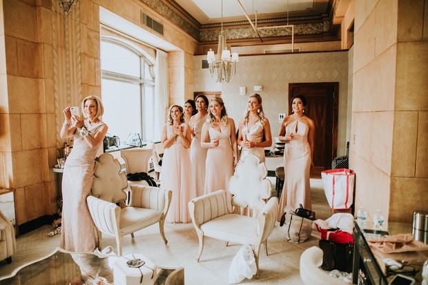 Bridesmaids excitedly take pre wedding photos together