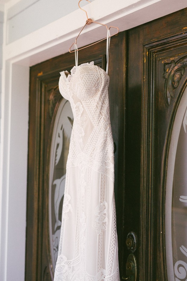 Lace wedding dress hanging on a wooden door hanger
