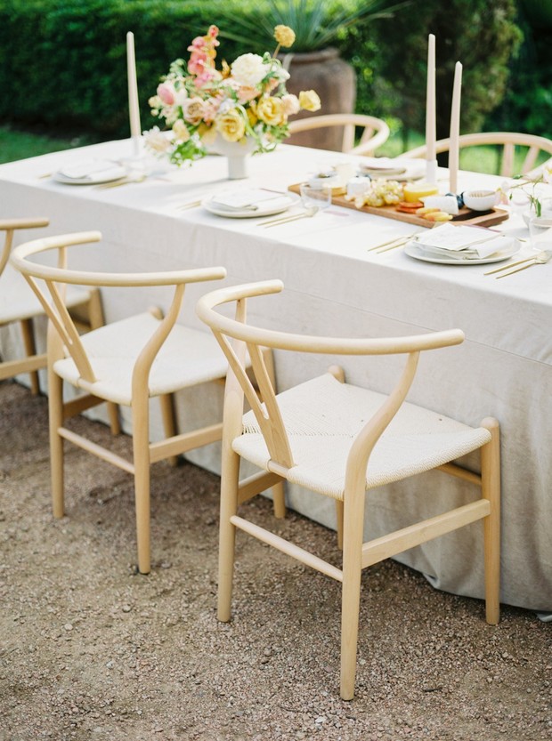 Elegant outdoor dining setup with wooden wishbone chairs