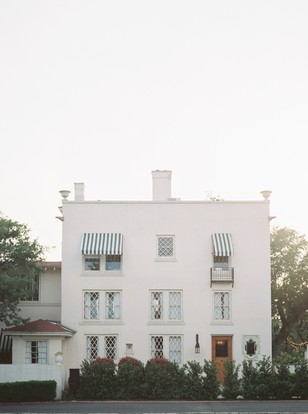White building facade with awnings and diamond windows