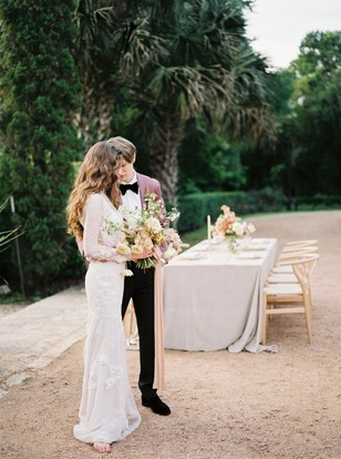 Bride and groom embrace at their outdoor wedding reception