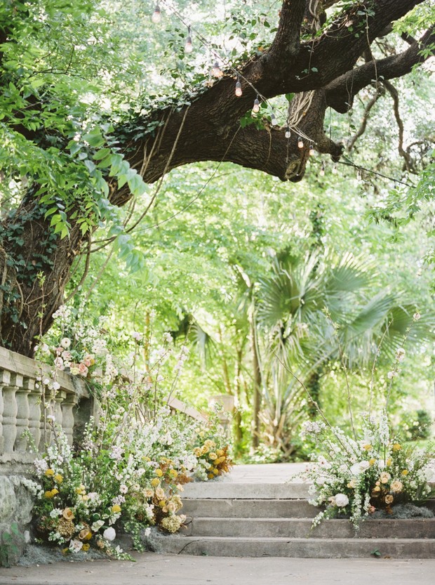 Stone steps decorated with floral arrangements in lush garden