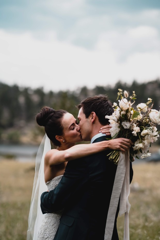Bride and groom sharing a tender kiss outdoors