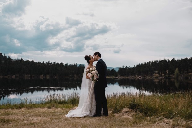 wedding kiss by a mountain lake