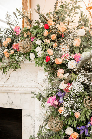 Elegant fireplace floral arrangement with roses and greenery