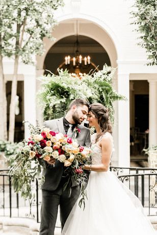 Bride and groom with vibrant bouquet at wedding venue