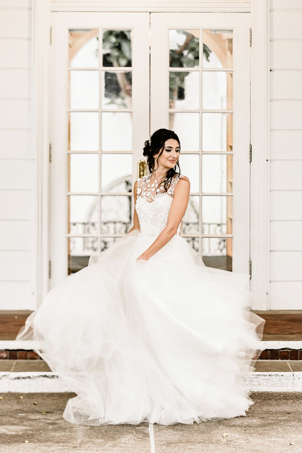 Elegant bride in a white wedding dress twirling outdoors