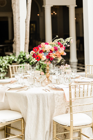 Elegant outdoor wedding reception with colorful floral centerpiece