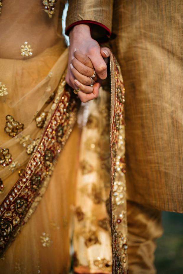 Indian wedding couple holding hands closeup view