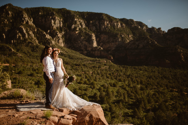 Happy couple posing for wedding photo on mountaintop