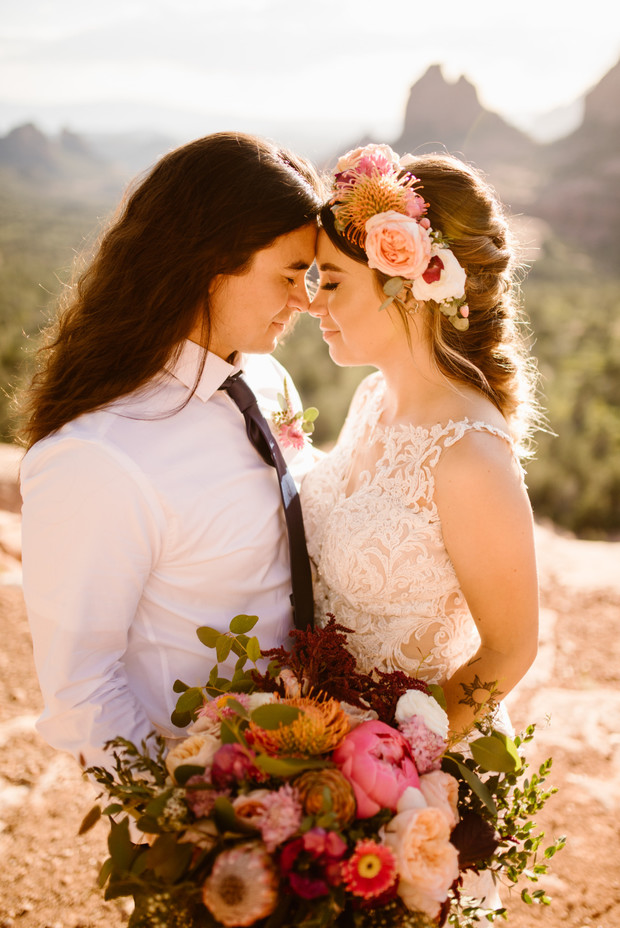 Bride and groom tenderly embrace in a scenic outdoor wedding