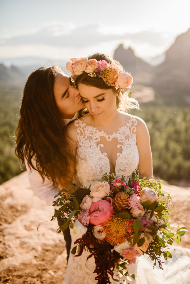 Bride and groom embrace, stunning bouquet, sunset elopement