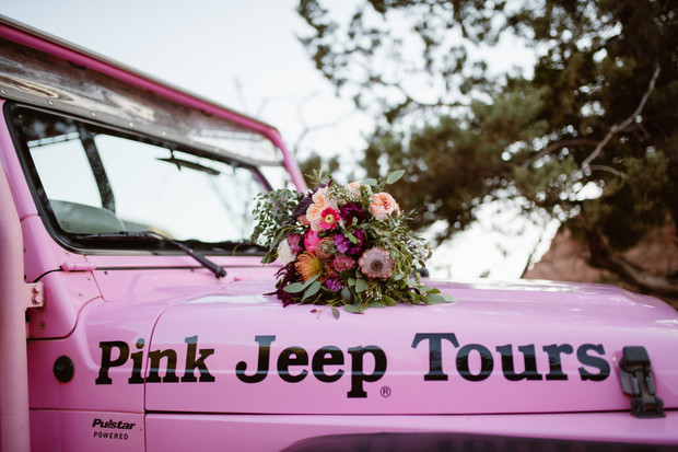 Pink Jeep Tours vehicle with a colorful flower bouquet