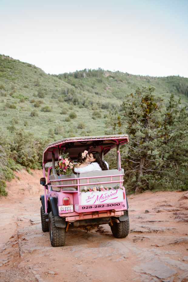 Just married couple in pink Jeep on a mountain road