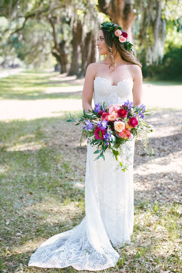 Elegant bride in lace dress with vibrant floral bouquet